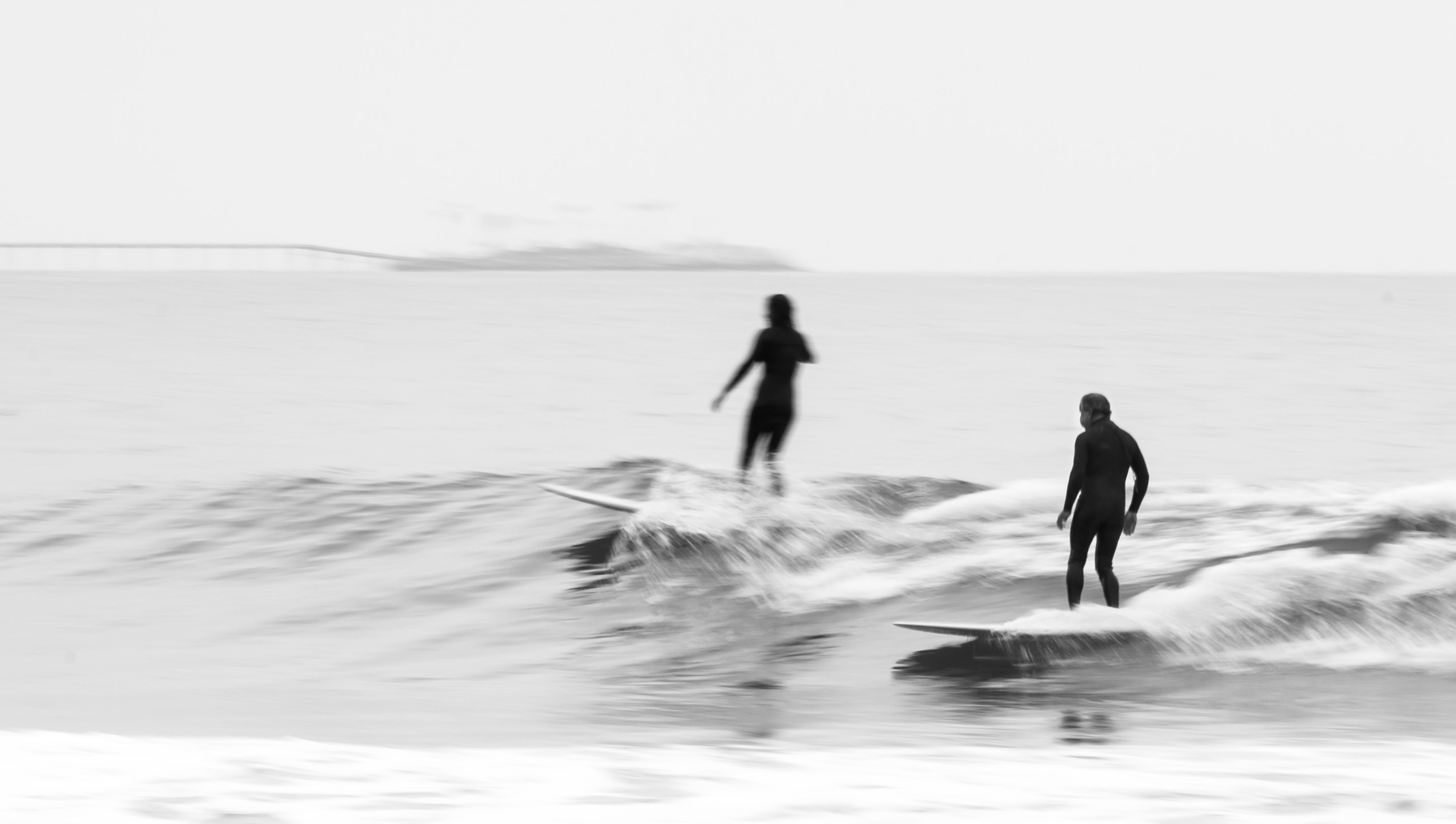 A black and white photo of speedy surfers. 