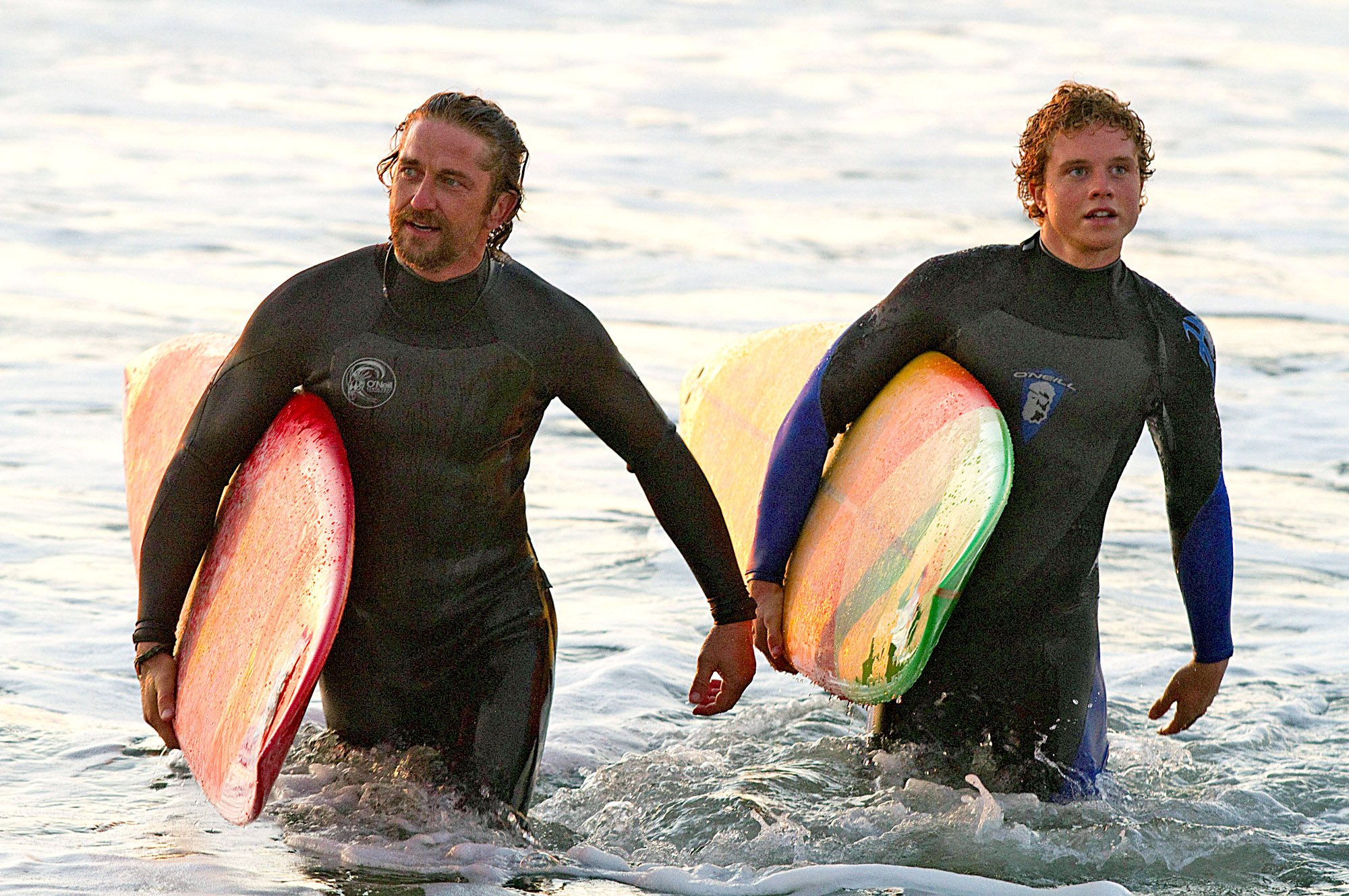 Surfers walking in water.