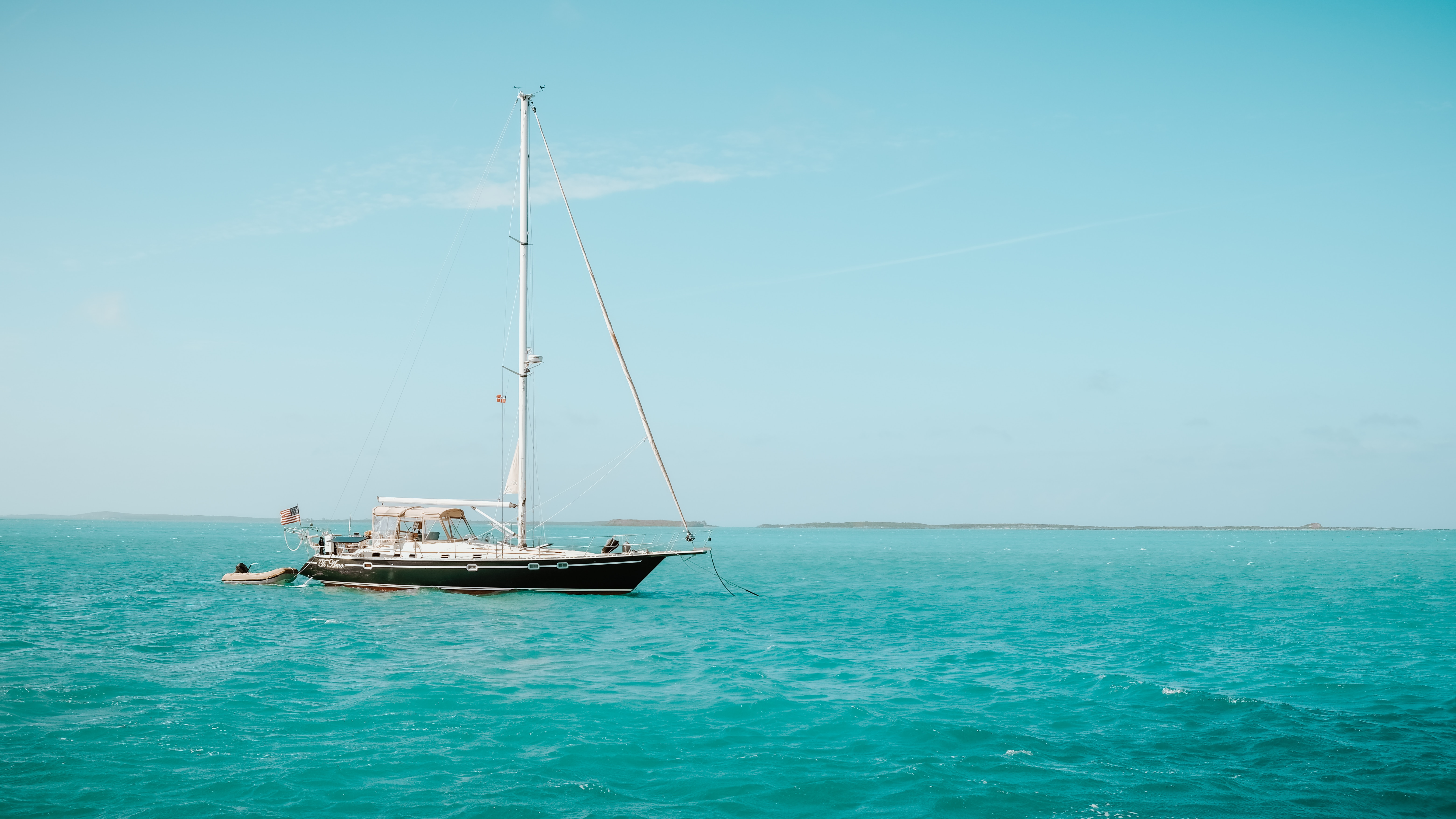 Sail boat on bright blue water.